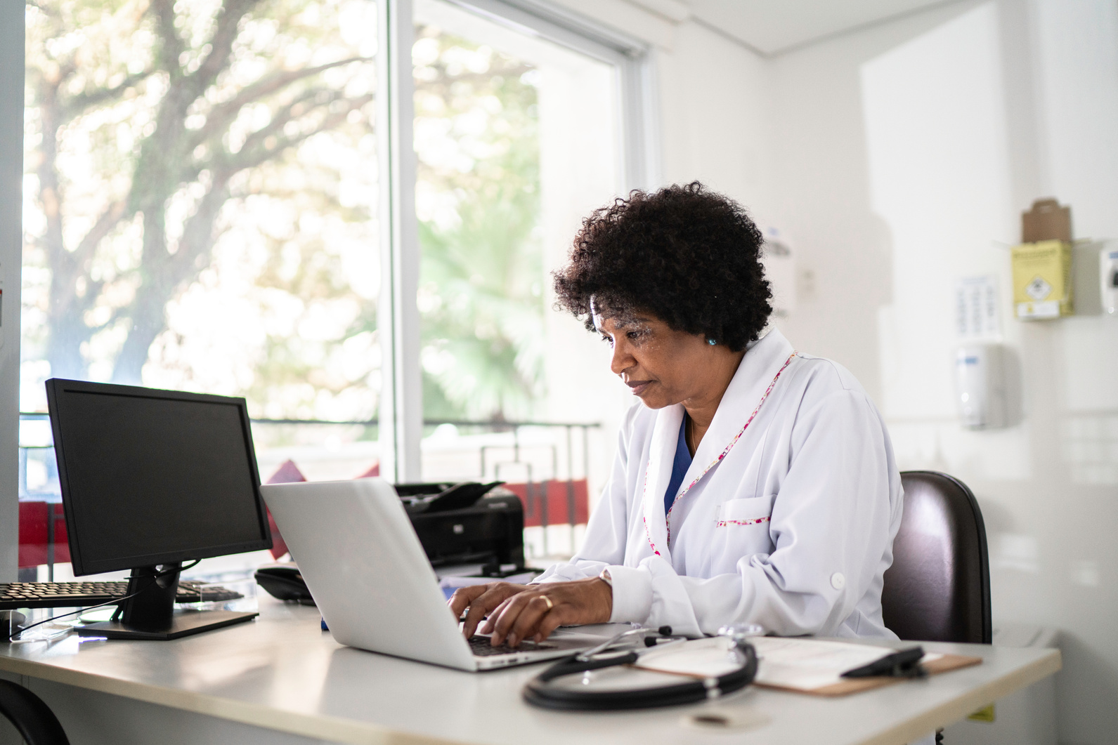 Mature female doctor using laptop at doctor's office